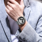 Close-up of a person wearing a silver watch with a gray suit jacket.