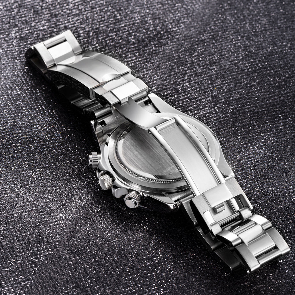 Silver watch with a detailed band on a textured black surface