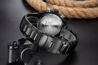 Black and silver watch with Canon camera on a dark background
