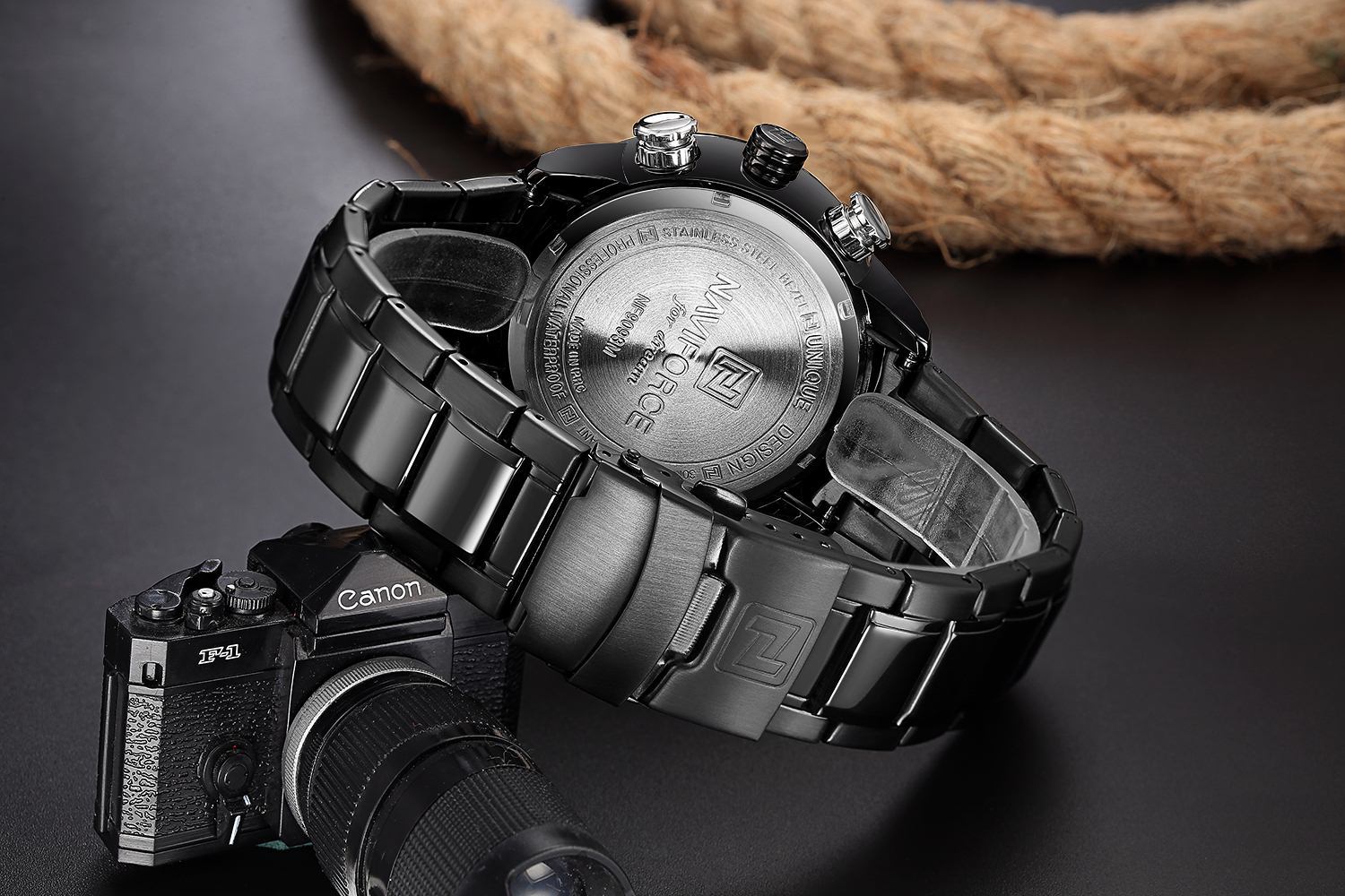 Black and silver watch with Canon camera on a dark background