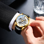 Person wearing a gold and black watch on a dark background