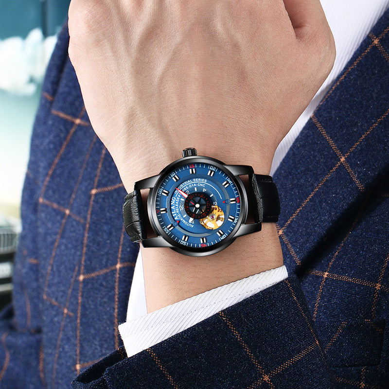 Person wearing a blue wristwatch with a detailed face, set against a blurred background.