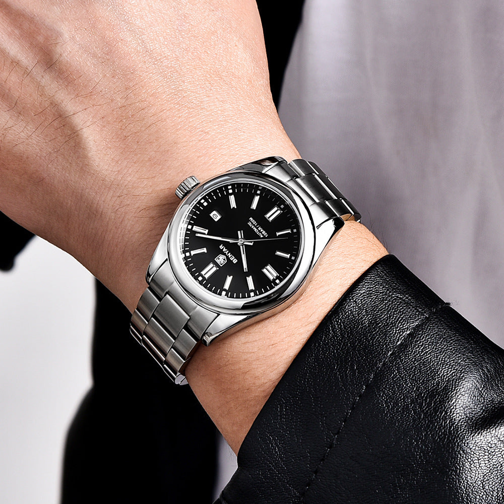Silver watch with black dial on a wrist against a neutral background